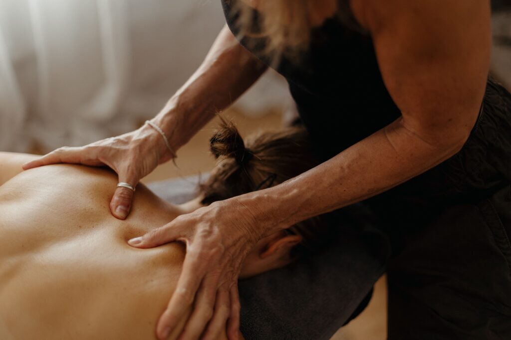 Therapist applying deep tissue pressure to client's back in Bath